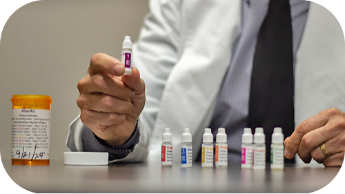 Thomas Willim, PA-C holding vial of allergy drops.
