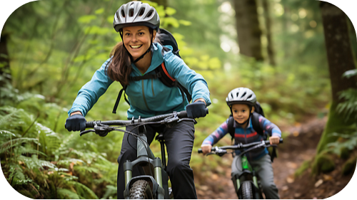 Mother and child on trail bicycles on trail in the woods, smiling and having fun.