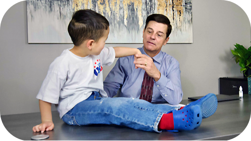 Thomas Willim, PA-C examining young boy's arm.