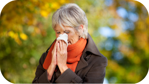 Middle age woman blowing nose.